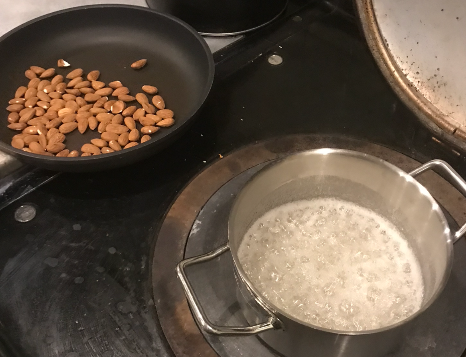 Pan of water and sugar, almonds nearby