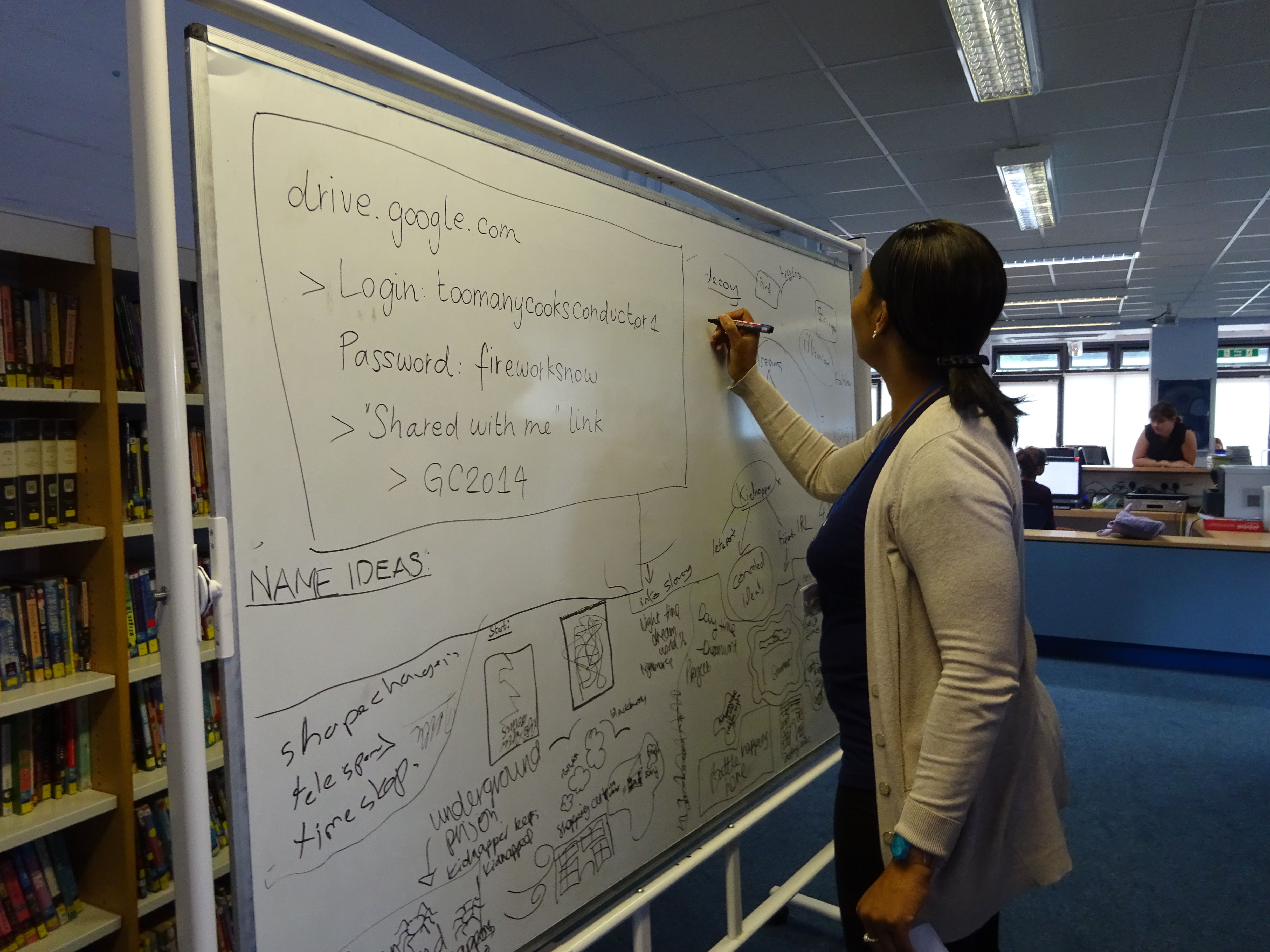 Team member writing on a whteboard in a school